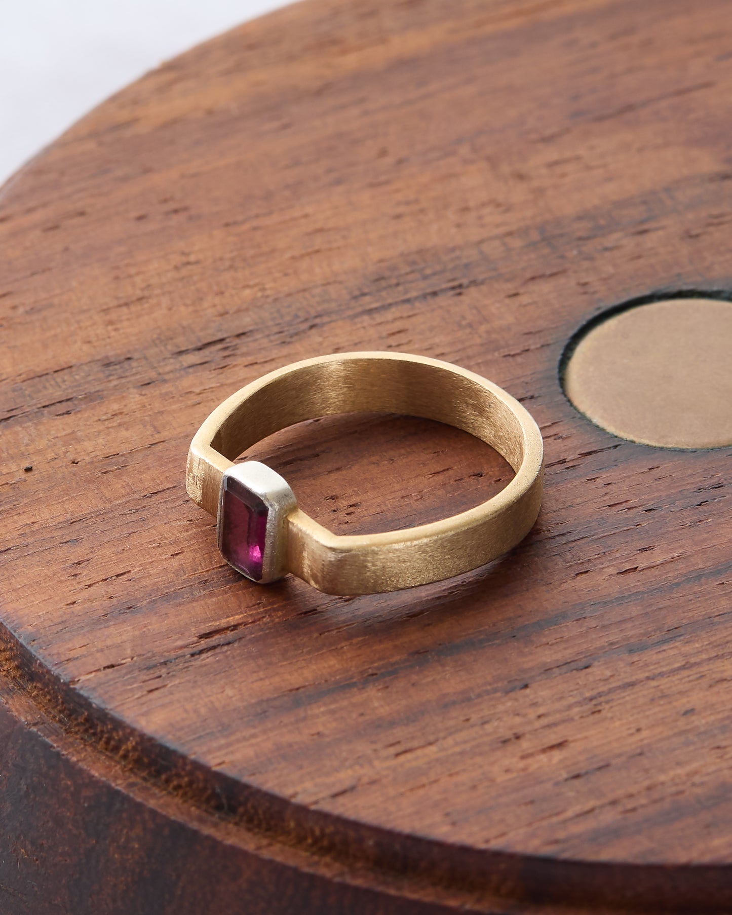 Close-up of the rhodolite cuff ring, highlighting the gemstone's faceted cut.