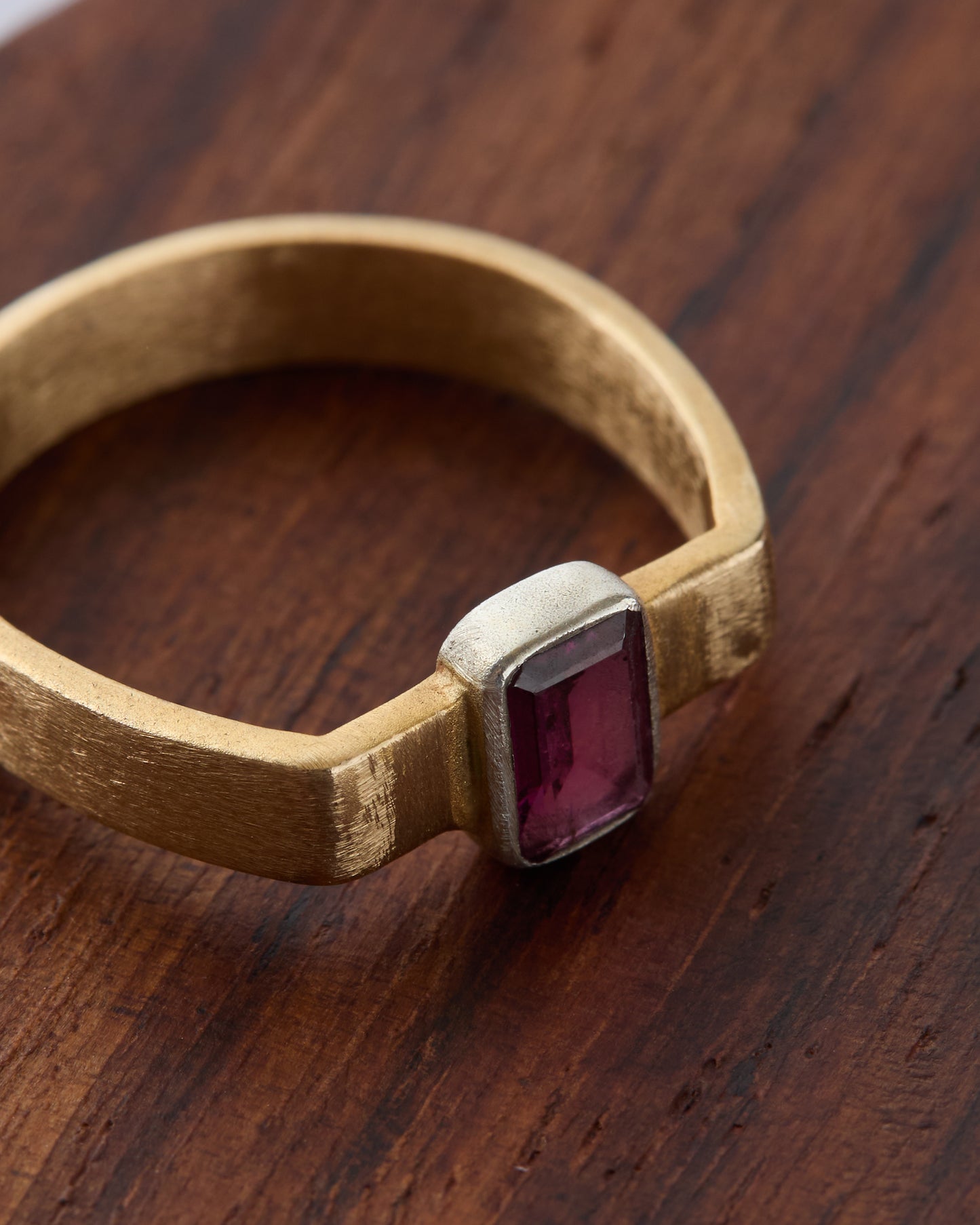 Detailed view of the ring's open cuff structure and gemstone setting.