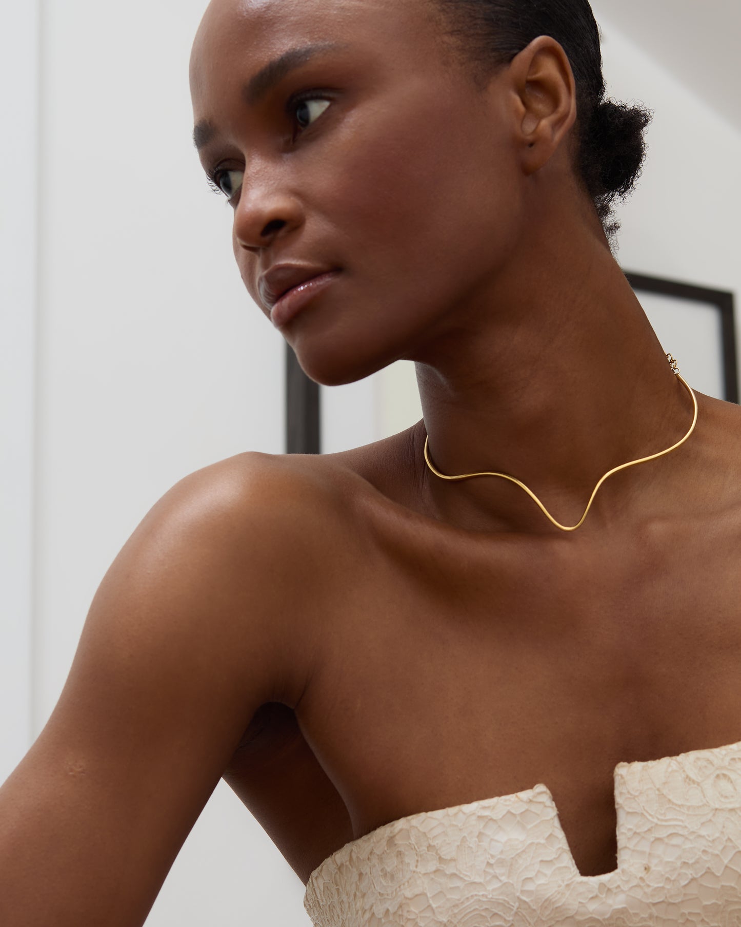 Minimalist gold torque necklace inspired by timeless silhouettes from Cartier and modern London ateliers