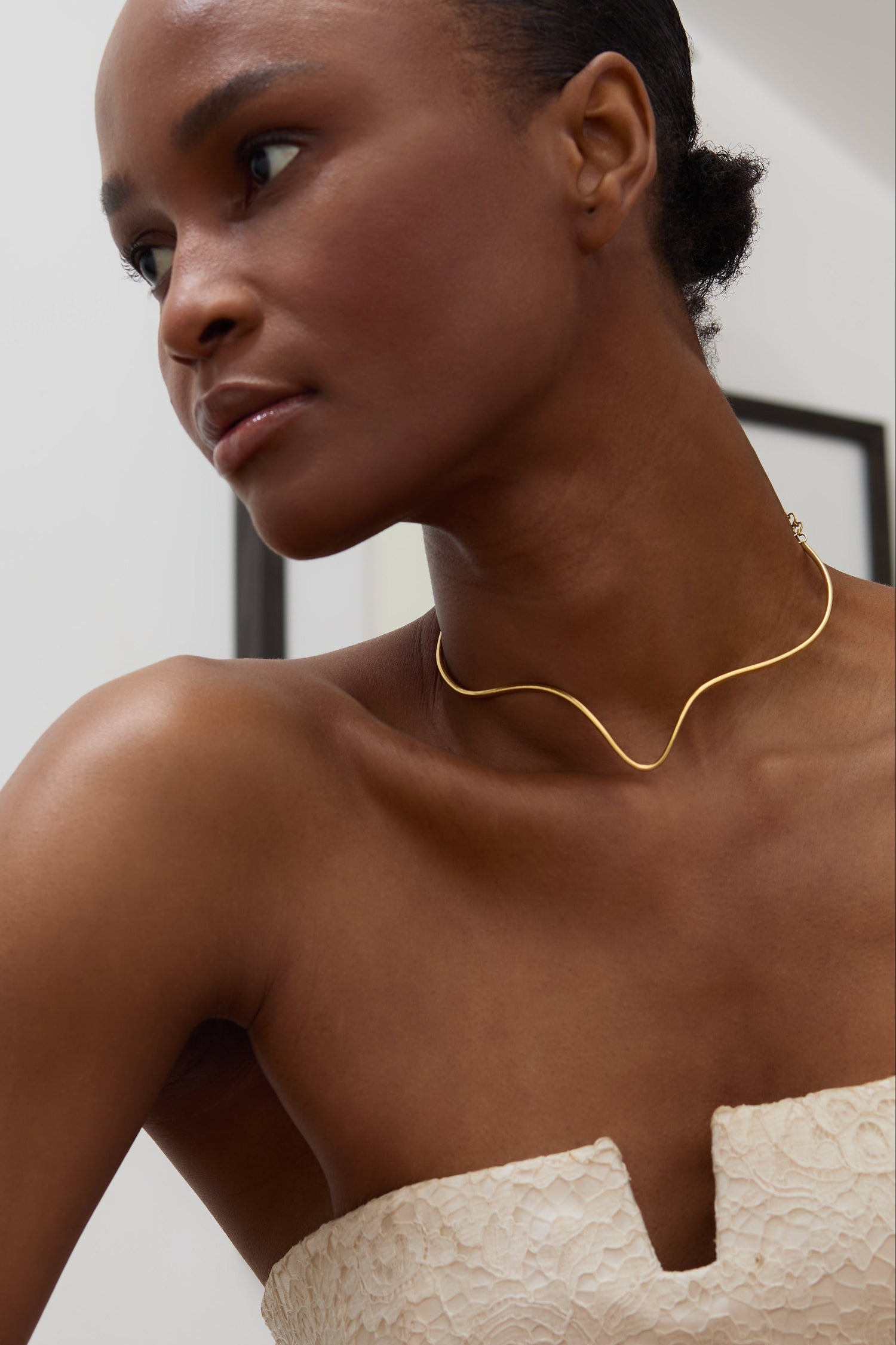 Minimalist gold torque necklace inspired by timeless silhouettes from Cartier and modern London ateliers