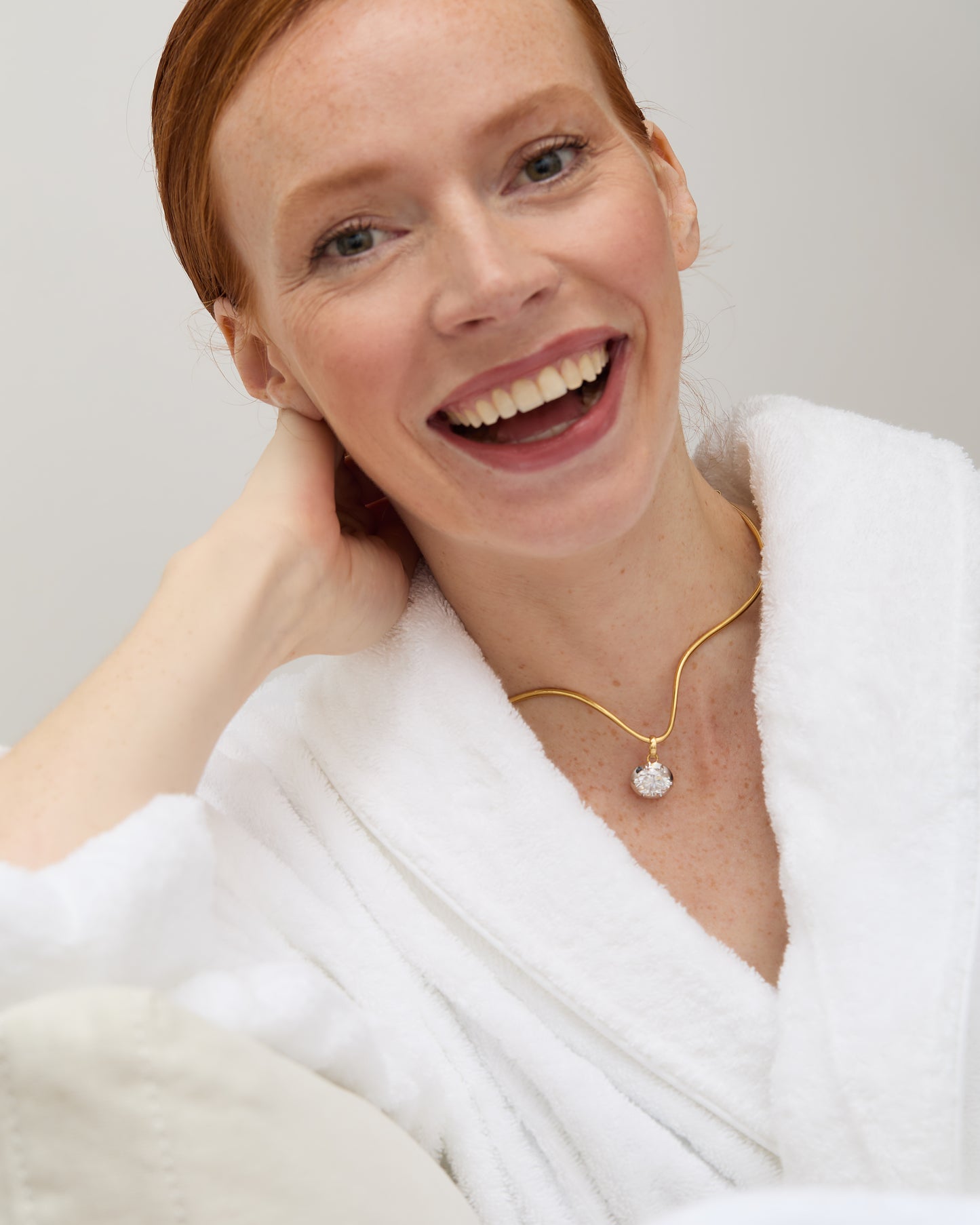 Model wearing the moissanite sunray pendant, capturing its sparkle in natural light.
