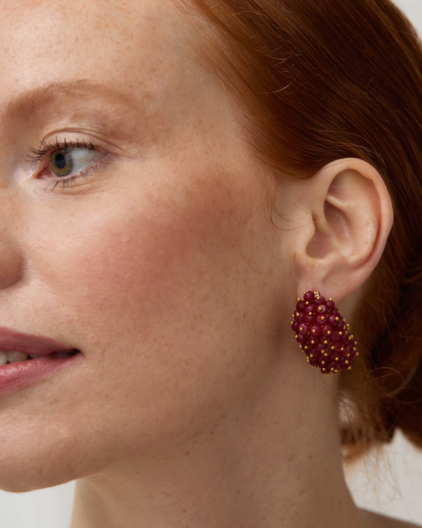 Close up of Model wearing the ruby & pearl drop earrings.