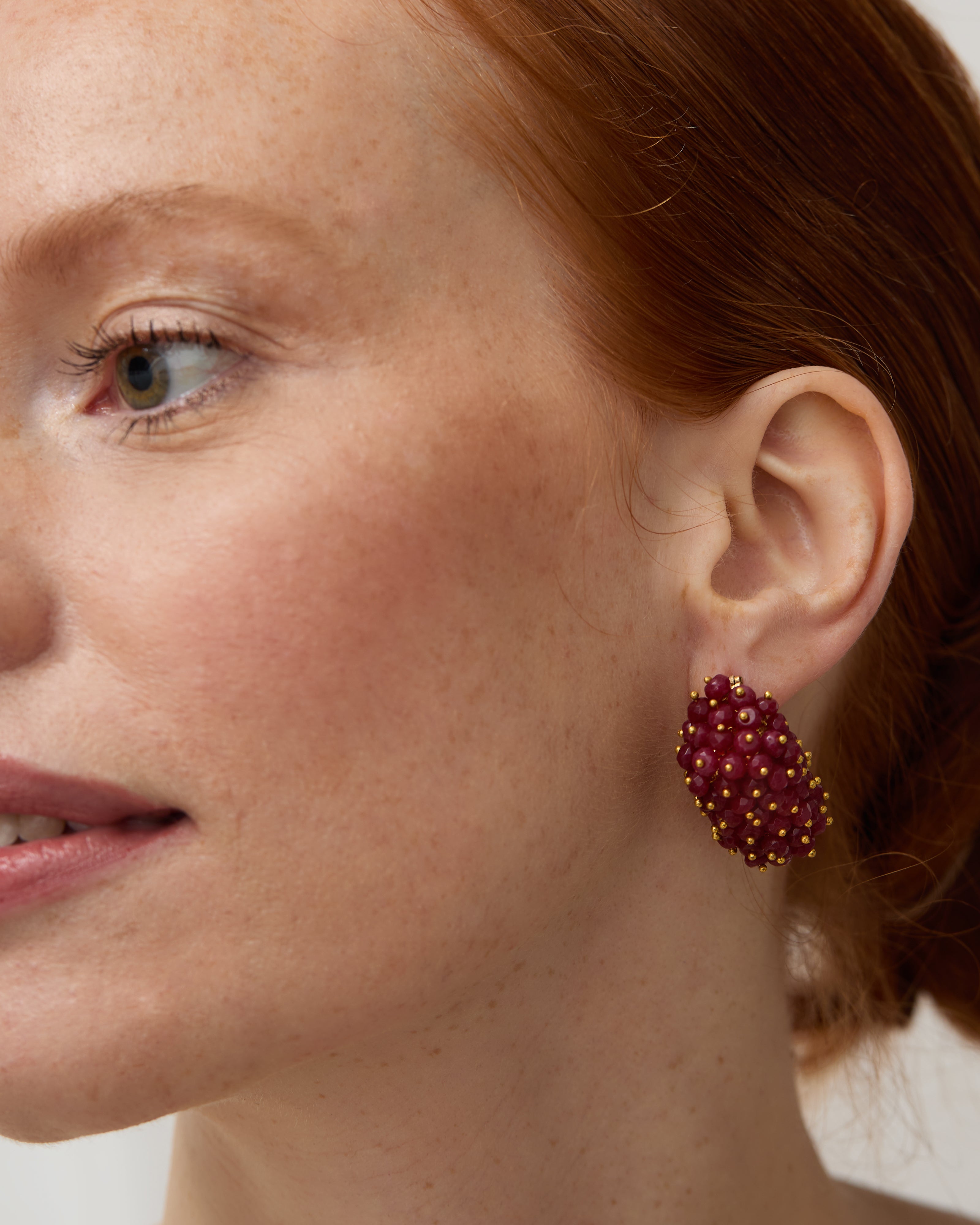 Close up of Model wearing the ruby & pearl drop earrings.