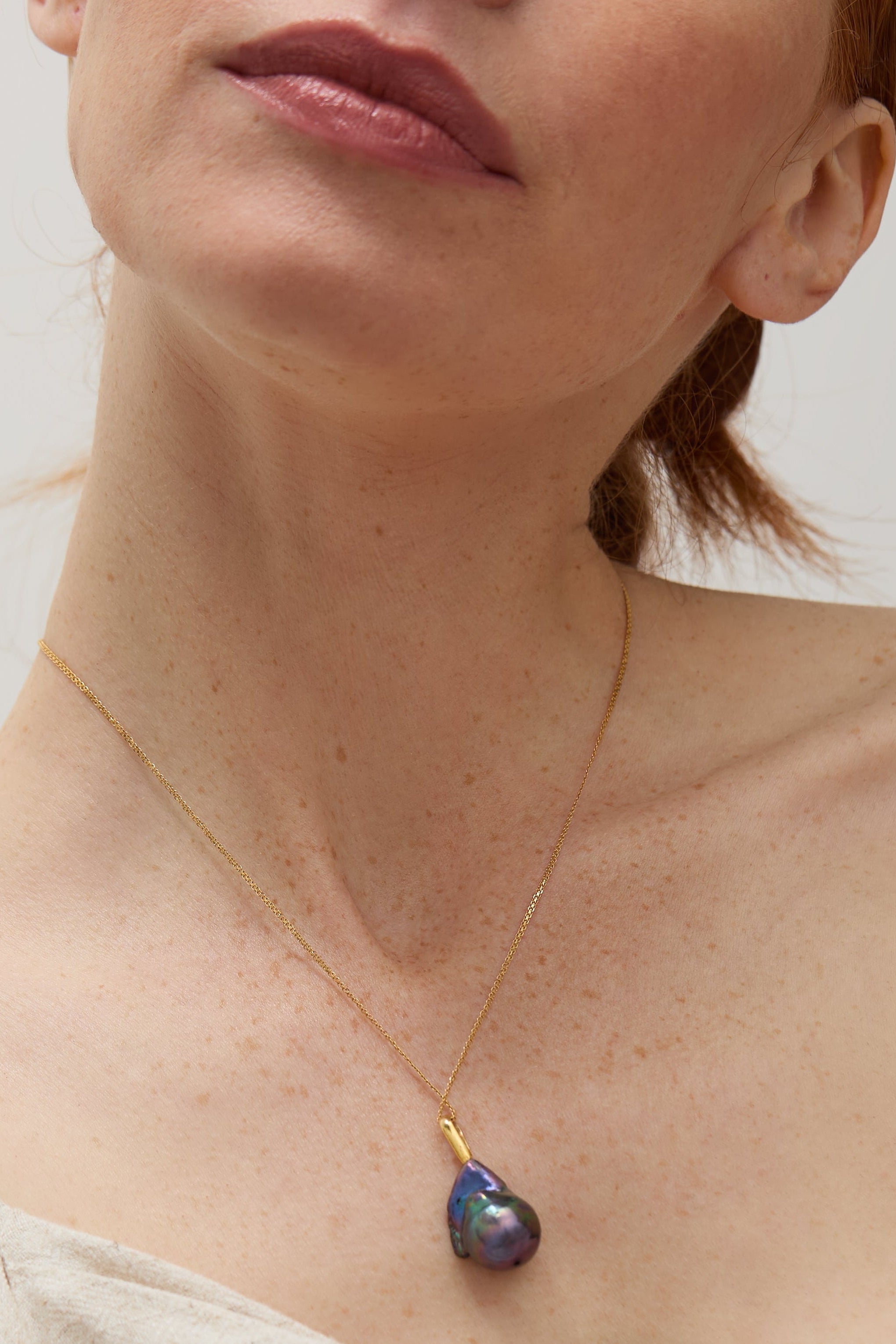 Model wearing the baroque pearl pendant, showcasing its elegant drop design.