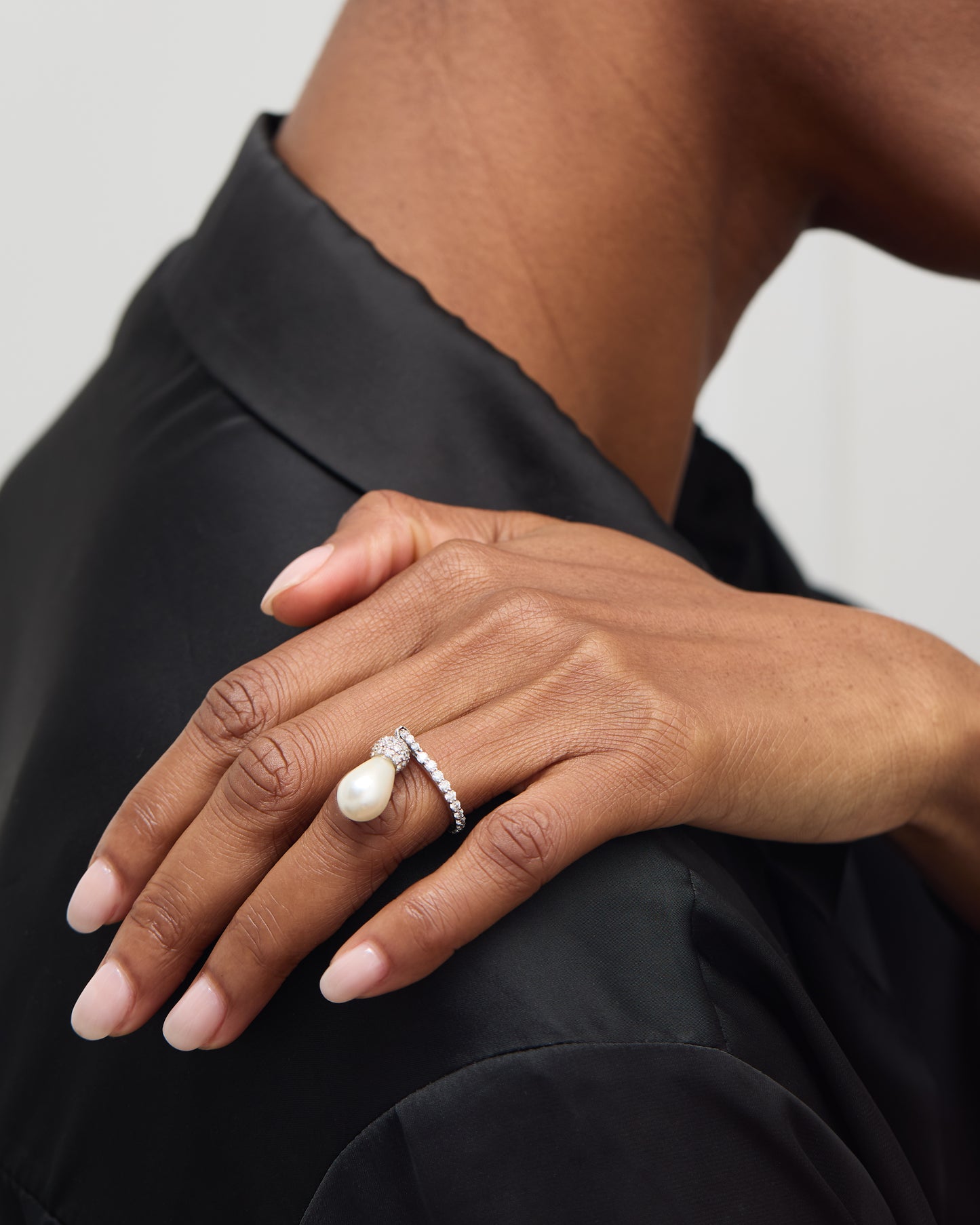 Detailed shot of the pearl's teardrop shape and the ring's gold band.