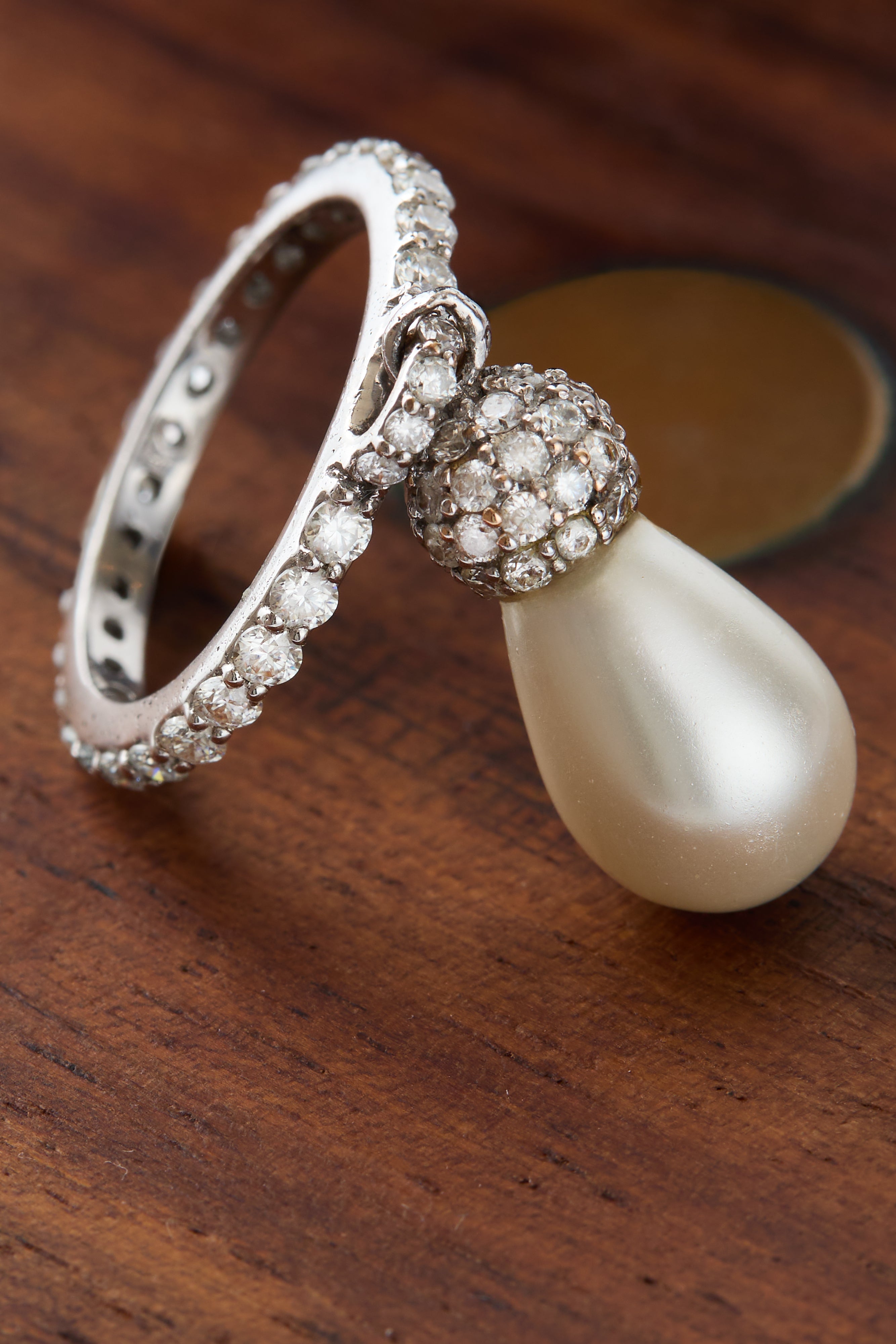 Detailed shot of the pearl's teardrop shape and the ring's gold band.
