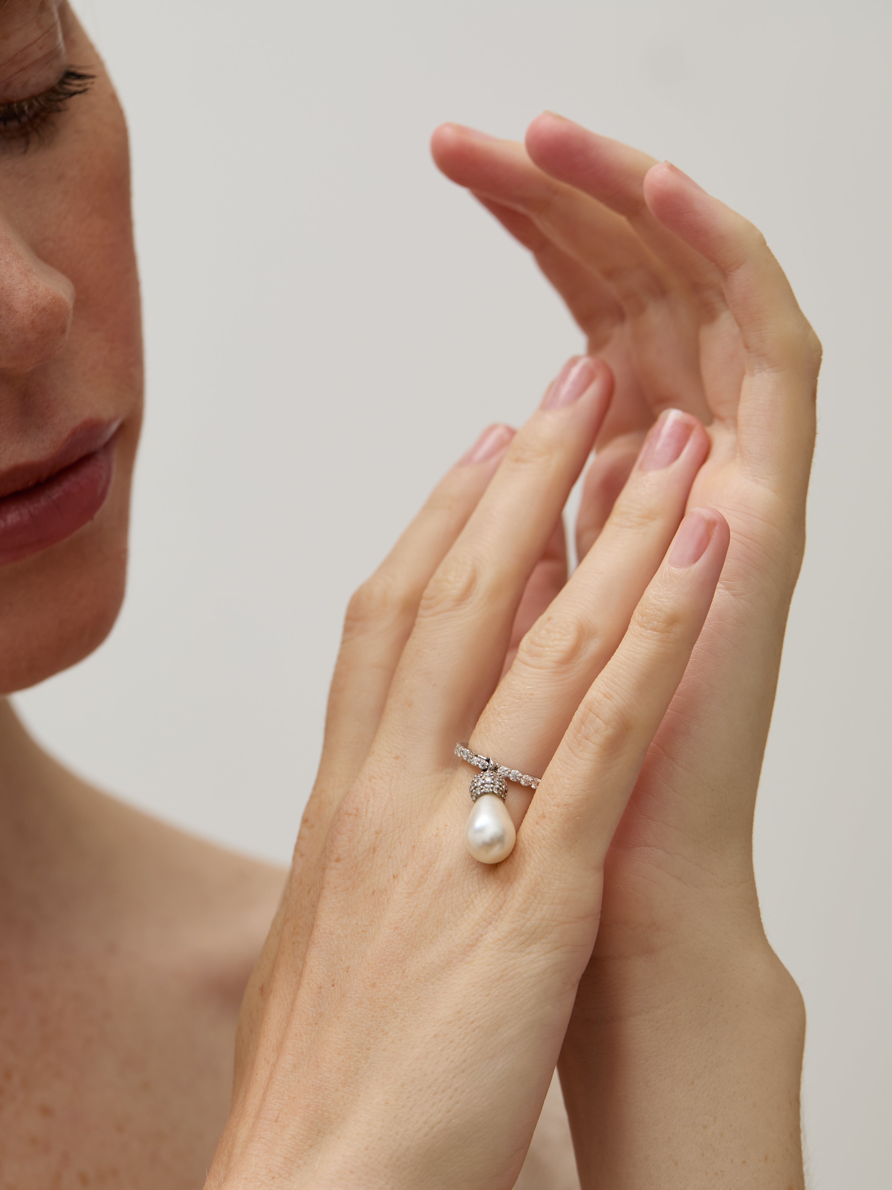 Model wearing the teardrop pearl ring, highlighting its delicate design.

